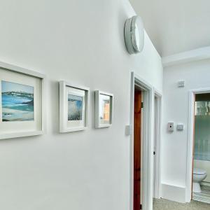 Pokój z trzema obrazami na ścianie i zegarem w obiekcie Liberty House w Weston-super-Mare