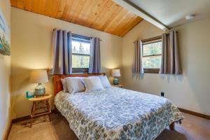 ein Schlafzimmer mit einem Bett und zwei Fenstern in der Unterkunft Serene Grand Lake Vacation Rental with Private Deck! in Grand Lake