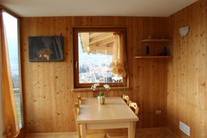 a wooden dining room with a table and a window at Agritur Fiore in Fondo