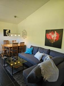 uma sala de estar com um sofá azul e uma mesa em Borrebjär em Varberg
