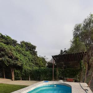 una piscina en un patio con pérgola en Casa de Campo Villa Angélica Lunahuaná en Lunahuaná