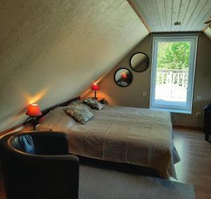 1 dormitorio con 1 cama con 2 lámparas y una ventana en Pärna Guesthouse & Apartments en Kuressaare