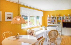 Awesome Home In Nynshamn With Sauna في نينس هامن: غرفة معيشة بجدران صفراء وطاولة وكراسي