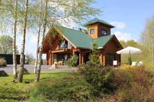 une grande maison en bois avec un toit vert dans l'établissement Golf.intersaxonia, à Zschopau