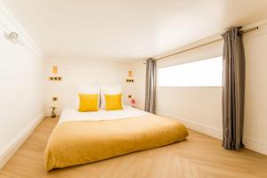 Luxury 4 bedroom 4 bathroom Apartment - Louvre في باريس: غرفة نوم بسرير كبير مع مخدات صفراء