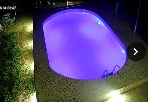 a purple swimming pool at night with a car at Casa de Campo Villa Angélica Lunahuaná in Lunahuaná