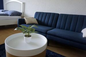 ein blaues Sofa und ein weißer Couchtisch im Wohnzimmer in der Unterkunft Appartement Traumblick in Bad Reichenhall