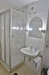 La salle de bains est pourvue d'une douche et d'un lavabo. dans l'établissement Appartement Traumblick, à Bad Reichenhall
