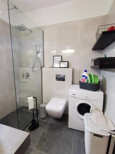 uma casa de banho com uma máquina de lavar roupa e um WC em Villa Steki em Roumelí