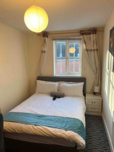 a bedroom with a large bed with a window at Peaceful 3 BR Flat with A View Near Hospitals-Free Parking in Newcastle under Lyme