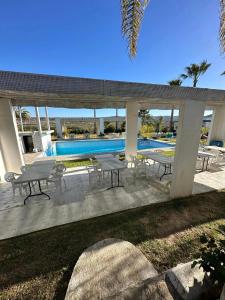 Nuevo UruapanにあるBaja best roomsのテーブルと椅子とプールのあるパティオ +7枚の写真