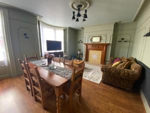 a dining room with a table and a couch at The Old Surgery Room Only in Scarborough