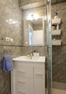 y baño con lavabo blanco y espejo. en Vivienda Turística Lore Artian., en Laguardia