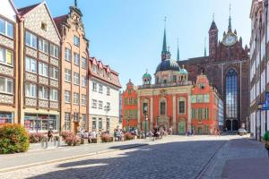 a city street with many buildings and a clock tower at Central Apartments Sz7-66 in Gdańsk