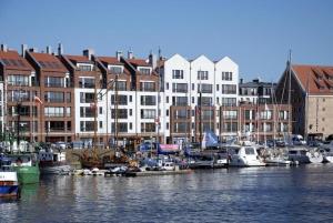 a group of boats docked in a harbor with buildings at Central Apartments Sz7-66 in Gdańsk