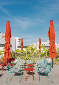 eine Gruppe von Stühlen und Tischen mit Sonnenschirmen in der Unterkunft The Boc Hostels - City in Palma de Mallorca