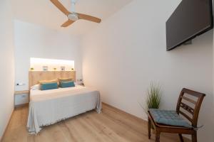 Schlafzimmer mit einem Bett, einem TV und einem Stuhl in der Unterkunft Casa junto al Mar in Vigo