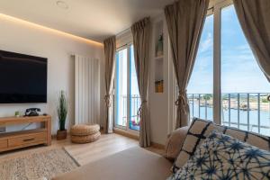 un soggiorno con TV e ampie finestre di Casa junto al Mar a Vigo