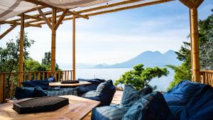 a deck with blue furniture and a view of the water at Eden Atitlan in San Marcos La Laguna