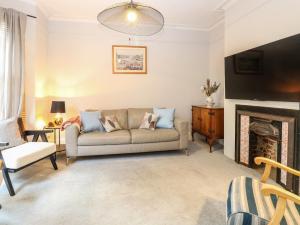a living room with a couch and a fireplace at Unthank Cottage in Norwich