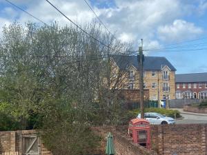 a red phone booth in front of a brick wall at The Old Surgery Room Only in Scarborough