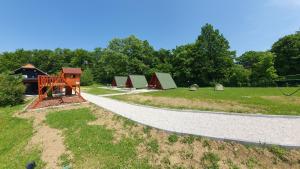 Kamp restavracija Gladiator في Žetale: طريق مع مجموعة من الخيام في الحديقة