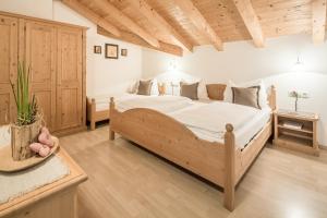 Un dormitorio con una cama grande en una habitación con techos de madera. en Residence Lärchwiese, en San Giacomo