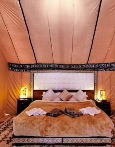 a bedroom with a large bed in a tent at Merzouga Sahara Camp in Merzouga
