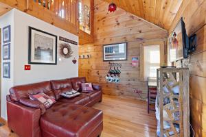 a living room with a leather couch and wooden walls at Cupids Retreat in Boone +26 photos