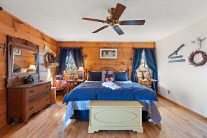 Un dormitorio con una cama azul y un ventilador de techo. en Cupids Retreat, en Boone