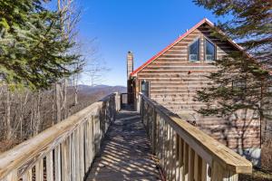 una pasarela de madera que conduce a una cabaña con una valla de madera en Cupids Retreat, en Boone