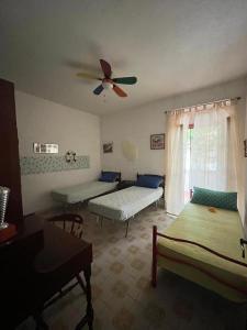 - un salon avec 2 lits et un ventilateur de plafond dans l'établissement Cuore di San Menaio Apartment, à San Menaio