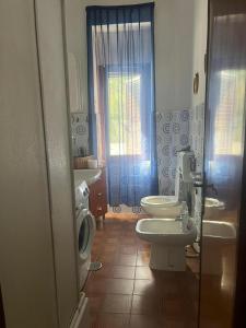 La salle de bains est pourvue de 2 toilettes, d'un lavabo et d'une fenêtre. dans l'établissement Cuore di San Menaio Apartment, à San Menaio