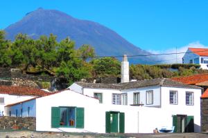 a white house with a mountain in the background at Casa do Cais in Monte