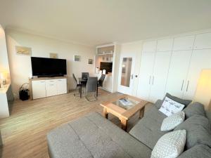 uma sala de estar com um sofá e uma mesa em Ferienpark Sierksdorf App 413 - Strandlage em Sierksdorf