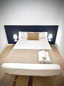 1 dormitorio con 1 cama blanca grande y 2 lámparas en Villa rooms, en Madrid