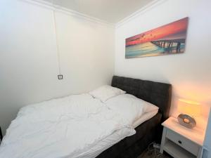 uma cama num quarto com um quadro na parede em Ferienpark Sierksdorf App 413 - Strandlage em Sierksdorf