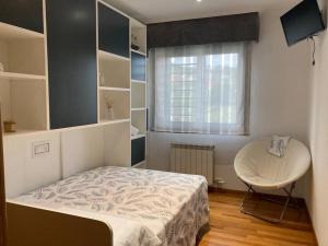 1 dormitorio con cama, mesa y ventana en HyP - El Nido de Iría, en Poio