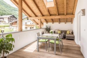 a patio with a table and chairs on a balcony at Residence Lärchwiese in San Giacomo