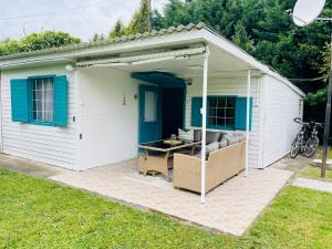 een kleine witte schuur met een tafel erin bij Csipkebogyó Nyaralóház - Siófok in Siófok