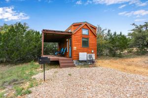 a tiny house sitting on top of a field at Arbor House of Dripping Springs - Hound Hollow in Dripping Springs