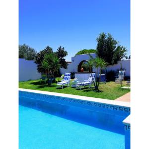 vista su una piscina con sedie e su una casa di Villa Lola 14 a Chiclana de la Frontera