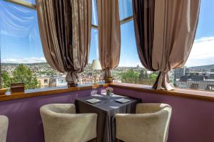 mesa y sillas en una habitación con ventana grande en A5 Hotel, en Tiflis