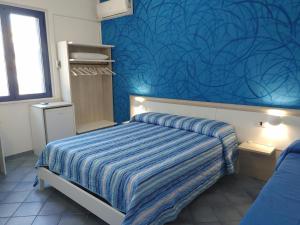 Bed and breakfast Delfino Blu في توري فادو: غرفة نوم بسرير وجدار ازرق