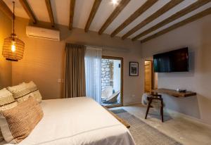 a bedroom with a bed and a tv on the wall at Casa Quebrada Hotel Boutique in San Miguel de Allende