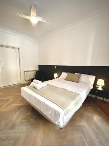 1 dormitorio con 1 cama grande y ventilador de techo en Villa rooms, en Madrid