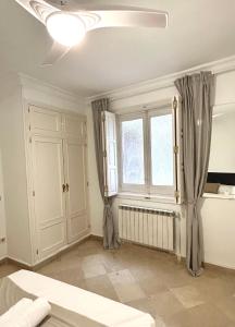 Habitación blanca con cama y ventana en Villa rooms, en Madrid