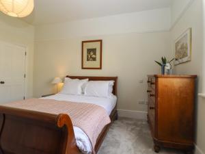 a bedroom with a bed and a wooden dresser at Archery Retreat in St. Leonards