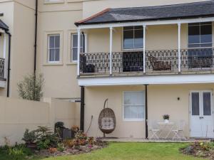 a house with a balcony with two chairs on it at Archery Retreat in St. Leonards
