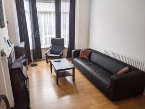 ノッティンガムにあるMaison Blancのリビングルーム(黒いソファ、椅子付)